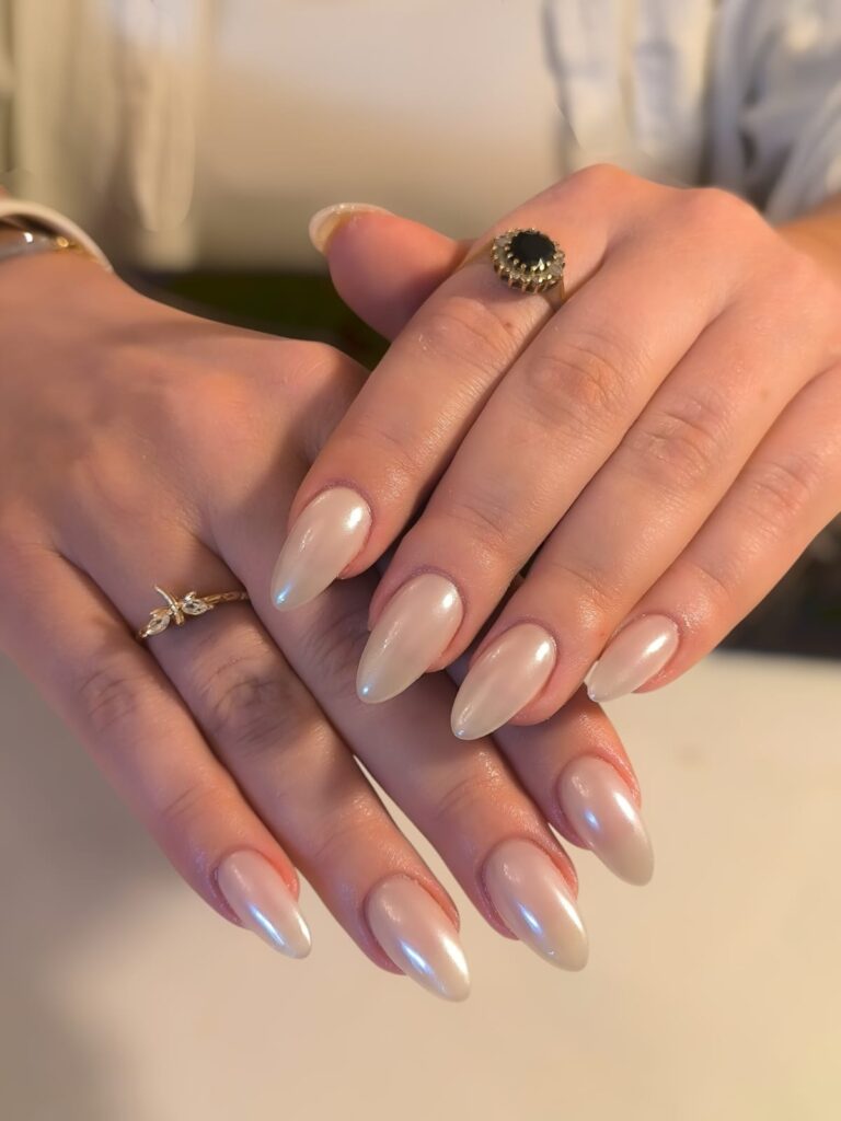 Glossy nude nail extensions on almond-shaped nails